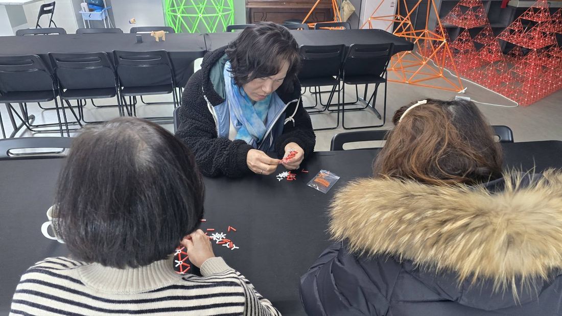 테이블에 둘러앉아 포디프레임을 조립하는 사람들