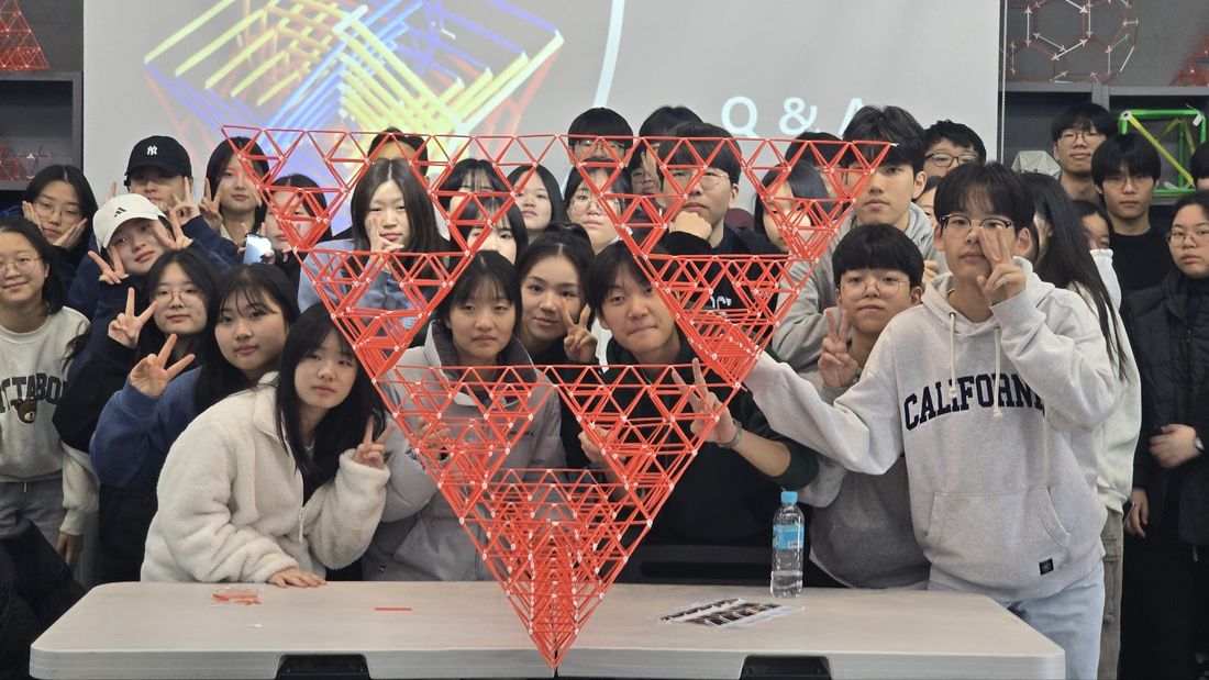 실내에서 완성한 큰 붉은 시에르핀스키 삼각형과 학생들