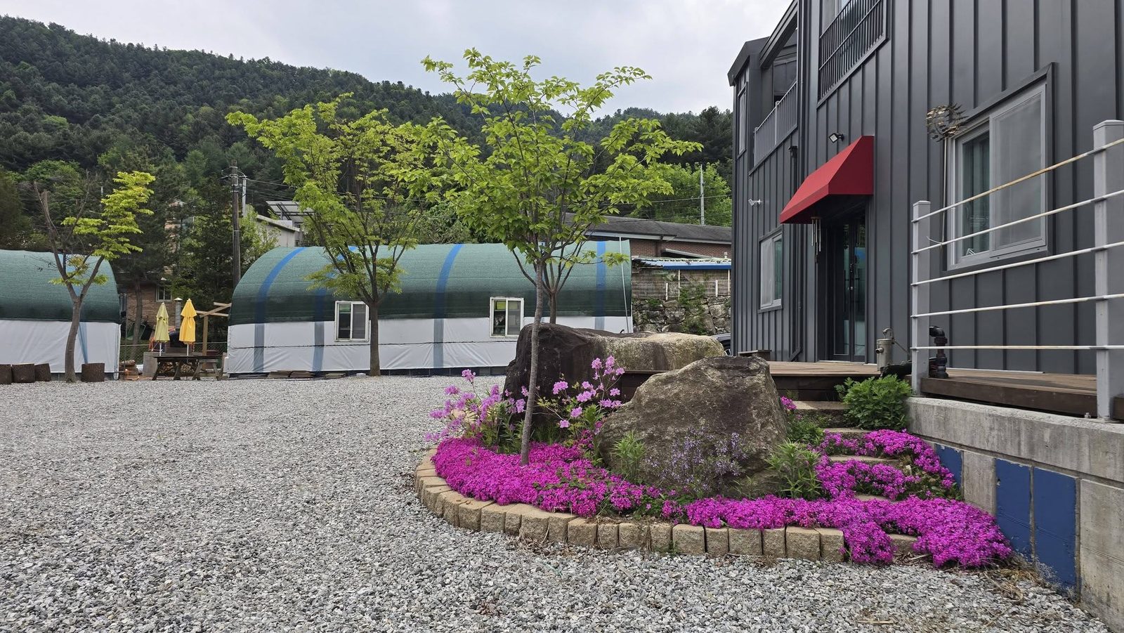 산으로 둘러싸인 포디융합연구소의 마당과 건물, 온실형 돔